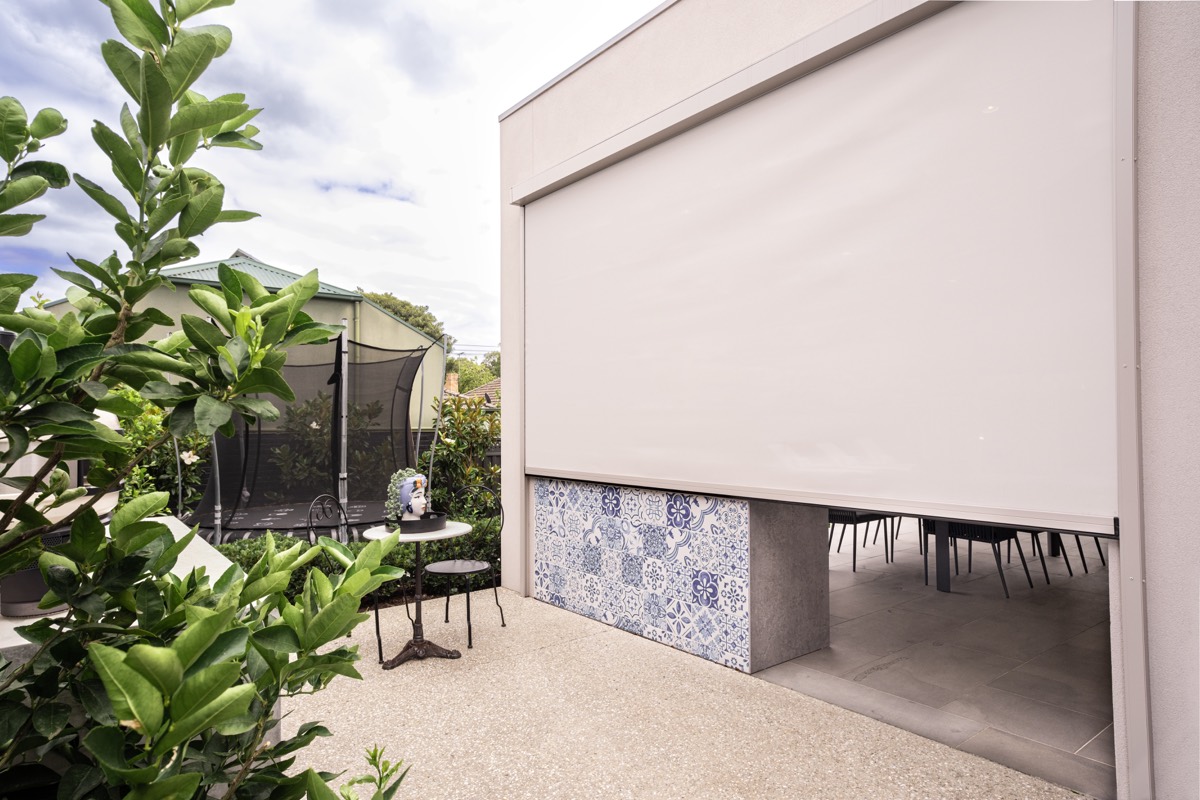 Cream Zipscreen closed over an outdoor kitchen servery with a tiled skirt below